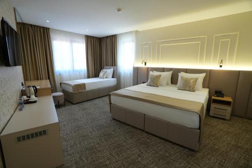 a hotel room with two beds and a couch at Avdissons Hotel in Prizren