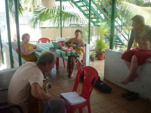 a group of people sitting around a table with a laptop at Jojies Homestay Fortkochi in Cochin