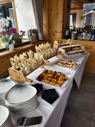 a table with plates and appetizers on top at Locanda La Baita in Santo Stefano di Cadore
