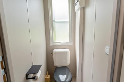 a small bathroom with a toilet and a window at Maison de Vacances - Parc de Vacances Papillon Bouillon in Bouillon