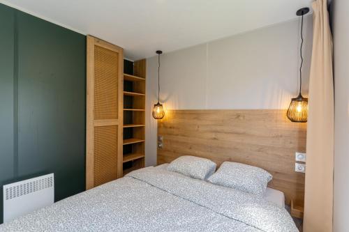 a bedroom with a bed with two pillows at Maison de Vacances - Parc de Vacances Papillon Bouillon in Bouillon