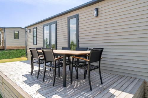 a wooden table and chairs on a deck at Maison de Vacances - Parc de Vacances Papillon Bouillon in Bouillon