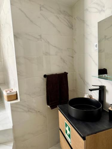 a bathroom with a black sink and a mirror at Casa do Viriato in Guarda
