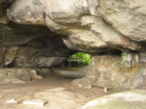 a rock cave with a bench in front of it at Apartment Schlafwandler in Steinigtwolmsdorf