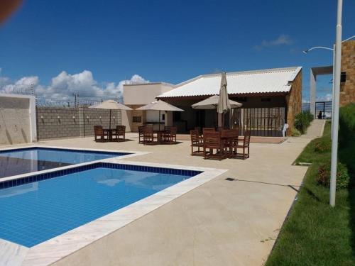 a swimming pool with tables and chairs next to a building at Casa Tibau in Tibau