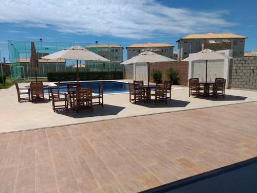 a patio with tables and chairs and umbrellas next to a pool at Casa Tibau in Tibau