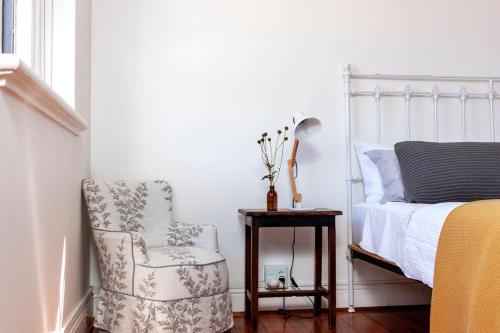 a bedroom with a bed and a chair and a side table at The Old School in McGregor