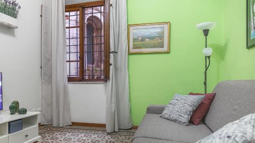 a living room with a couch and a green wall at Casa di Olga - Historical Apartment inside the Walls in Lucca