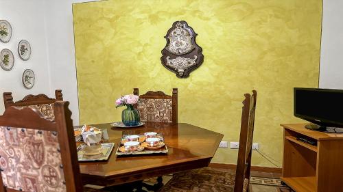a dining room with a table and a tv at Casa di Olga - Historical Apartment inside the Walls in Lucca