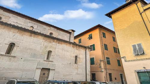a group of buildings with cars parked next to them at Casa di Olga - Historical Apartment inside the Walls in Lucca