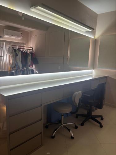 a kitchen with a counter with a chair and a desk at Apartamento mobiliado in Cachoeiro de Itapemirim