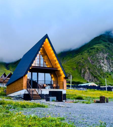 a house with a black roof on a mountain at Chill inn kazbegi in Stepantsminda