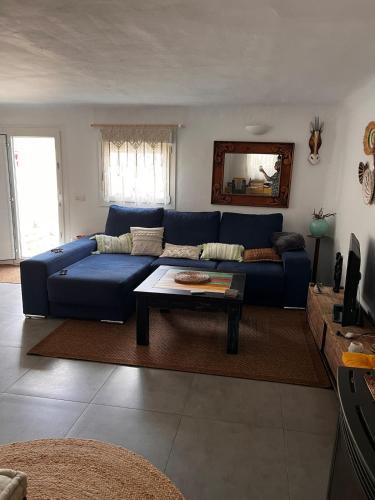 a living room with a blue couch and a table at Blue house Nature and calm in Tarifa