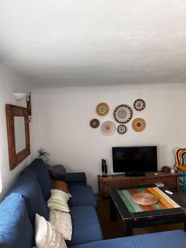 a living room with a blue couch and a table at Blue house Nature and calm in Tarifa