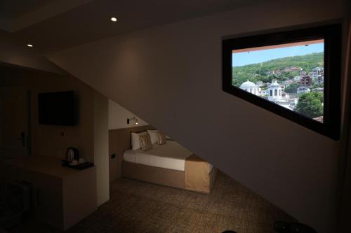 a bedroom with a bed with a large window at Avdissons Hotel in Prizren