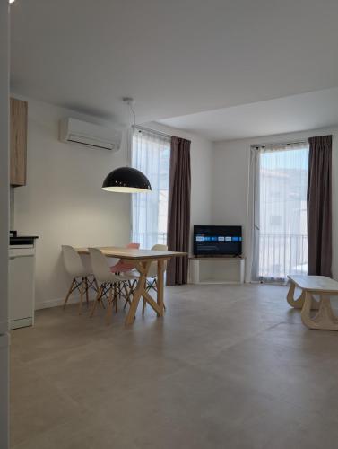 a living room with a table and chairs and a television at Ca l'Emília, hasta 6 pers, Monistrol de Montserrat in Monistrol