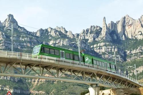 a green train on a bridge over a mountain at Ca l'Emília, hasta 6 pers, Monistrol de Montserrat in Monistrol