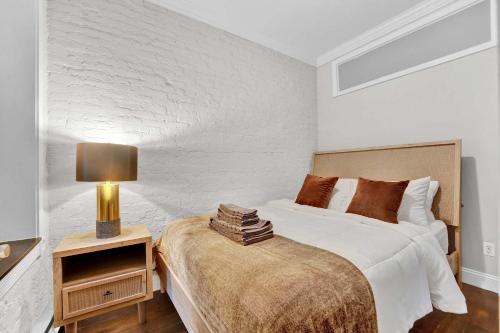 a bedroom with a bed and a lamp on a night stand at Modern 3BR in Gramercy -Near Union Sq NYU in New York