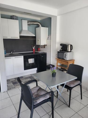 kuchnia ze stołem i krzesłami w pokoju w obiekcie Residence d'Anjou - Grand studio avec balcon et parking privatif w Perpignanie