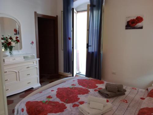 a bedroom with a bed with a dresser and a mirror at Appartamento vacanze Le rose in Bosa