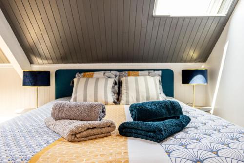 une chambre avec un lit avec des oreillers dessus dans l'établissement Agréable cocon sous les toits - Parking - WiFi, à Pléneuf-Val-André