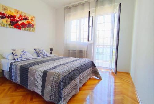 a bedroom with a bed and a large window at Apartment Tea 2 in Okrug Donji