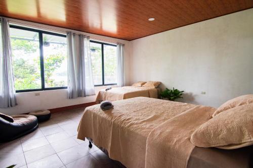 a bedroom with two beds and a large window at Casa Anita in San Juan La Laguna