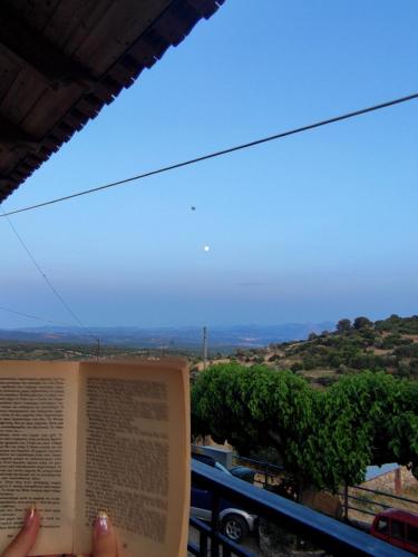 a person is reading a book on a balcony at Ανέμη in Panayía