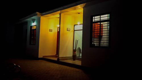 een kamer met een deur en een raam 's nachts bij Roseney Home in Dar es Salaam