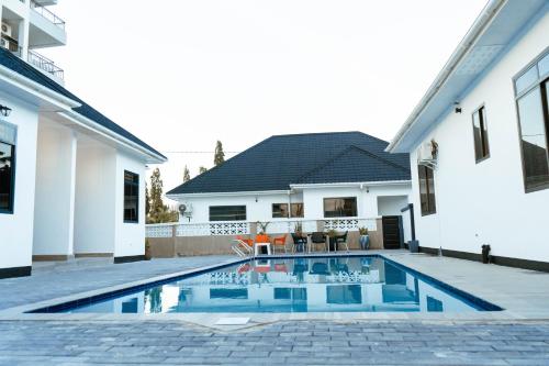 een zwembad in de achtertuin van een huis bij Roseney Home in Dar es Salaam