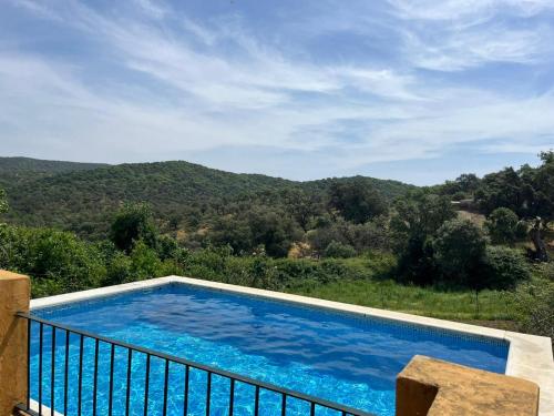 a swimming pool with a view of a mountain at Puerto los Pinos in Cortegana