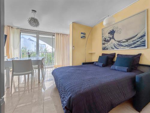 1 dormitorio con 1 cama grande y mesa de comedor en T2, Calme & lumineux, au bout du jardin, la plage!, en La Grande-Motte