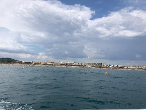 une grande étendue d'eau avec une plage en arrière-plan dans l'établissement Le C 69 Cap d'Agde naturiste, au Cap d'Agde