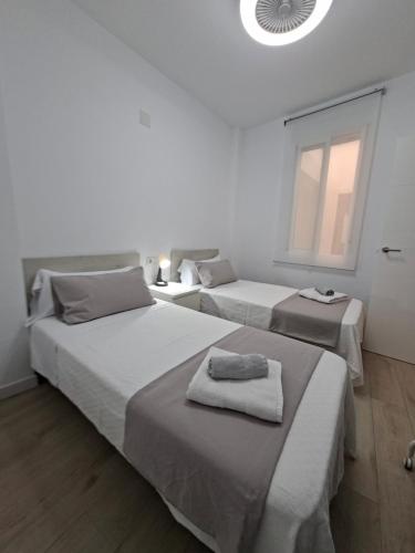 ein Schlafzimmer mit zwei Betten mit Handtüchern darauf in der Unterkunft La Casita del Tío in Santa Pola