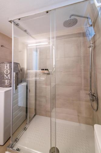 a shower with a glass door in a bathroom at eleni luxury apartment in Tinos Town