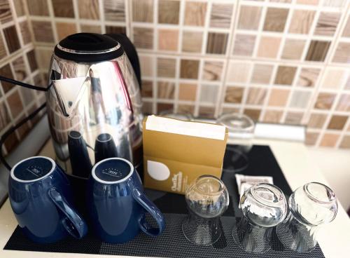 a counter top with a coffee pot and glasses at Domus Komanesse - Guest Houses in Koman