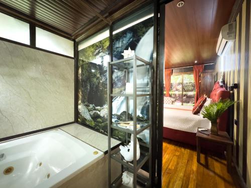 a bathroom with a tub and an aquarium at Hotel Heliconias Nature Inn & Hot Springs in Fortuna