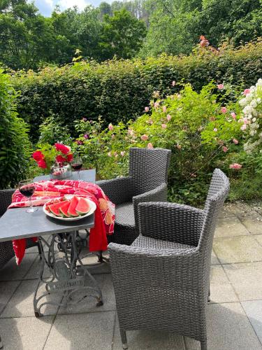 a table and chairs with a plate of watermelon on it at Haus Menuett in Bad Schandau