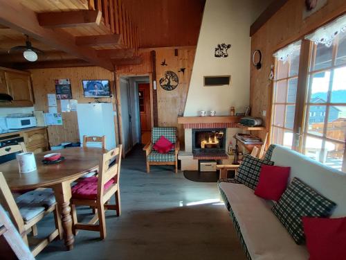 Il dispose d'une cuisine et d'un salon avec une table et une cheminée. dans l'établissement Les Gîtes Du Pré Nouveau, à Prénovel