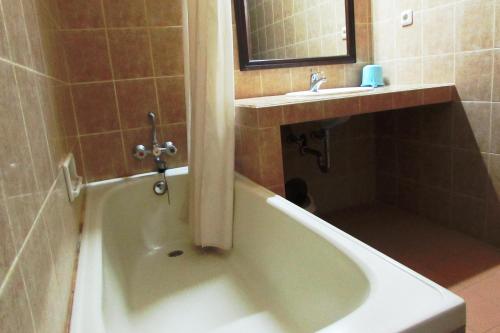 a bathroom with a bath tub and a sink at Griya Ayu Inn in Sanur