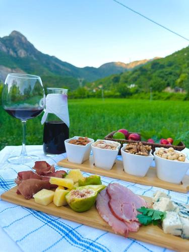 a table with plates of food and a glass of wine at Domus Komanesse - Guest Houses in Koman