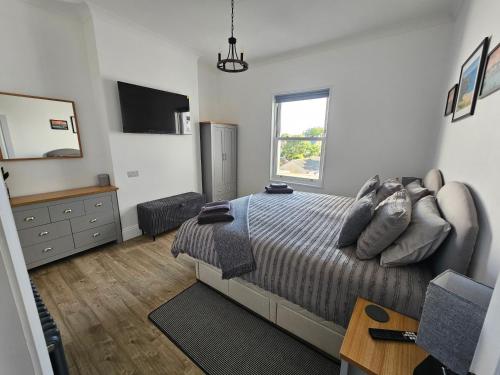 a bedroom with a bed and a dresser and a window at The Nest in Weymouth in Weymouth