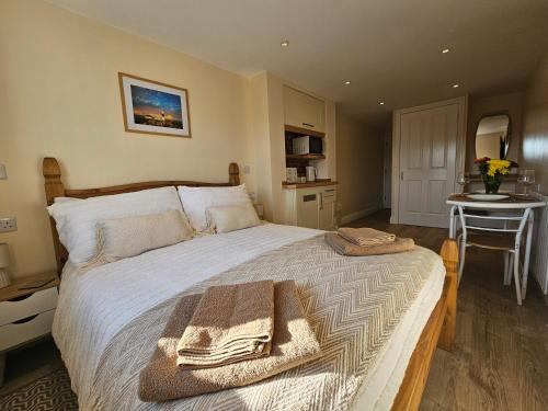 a bedroom with a large bed with towels on it at The Nest in Weymouth in Weymouth