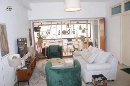 a living room with a white couch and chairs at Citycomfortluanda in Luanda