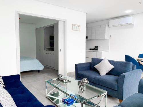 a living room with blue couches and a glass table at Airbnb Guayaquil, Mall del Sol, Piso alto in Guayaquil