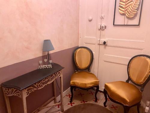 une chambre avec deux chaises, un bureau et une porte dans l'établissement Les Lauriers Duplex centre ville avec jardin, à Nyons