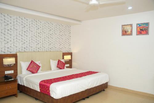 a bedroom with a large bed with red pillows at Hotel Occassia Bliss Miyapur in Lingampalli