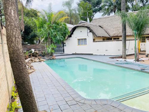 a large swimming pool in front of a house at Harmony Spaces in Kempton Park