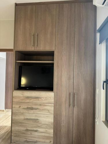 a large wooden cabinet with a television in it at Anna's House in Kos Town