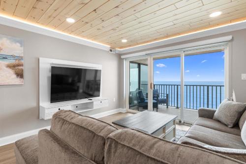a living room with a couch and a flat screen tv at Spectacular Oceanfront Penthouse - Unit 1203 in Ocean City